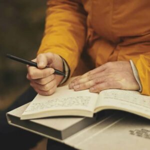 Man writing on notepad after completing the Complete Writing Course