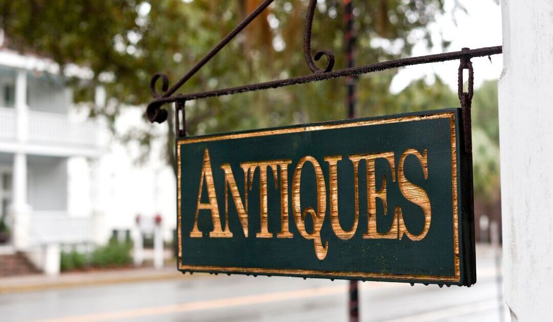 Sign pointing to shop for someone who has learned how to sell antiques
