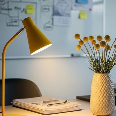 A small desk lamp shining down on a laptop