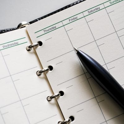 Close up of a blank work planner and pen
